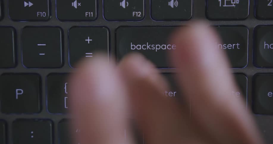 A persons fingers are pushing keys on a laptop computer keyboard