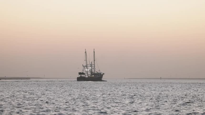 Boat moving over the calm sea waters at evening