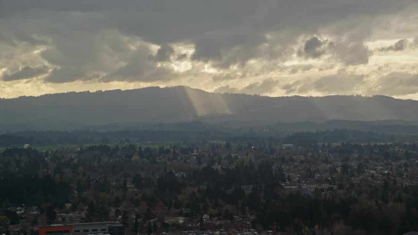 Aerial view of sunlight shining through clouds over a town