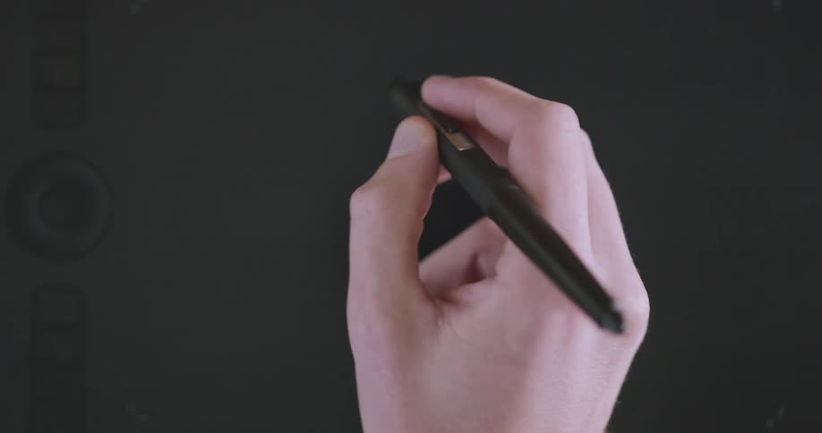 A person writing with a black pen on a blackboard