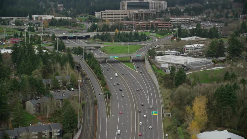 Aerial of the highway with heavy traffic in a residential neighborhood during the day