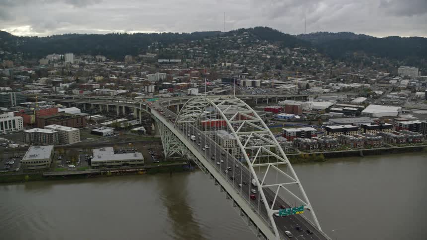Vehicles travel over the bridge into the city