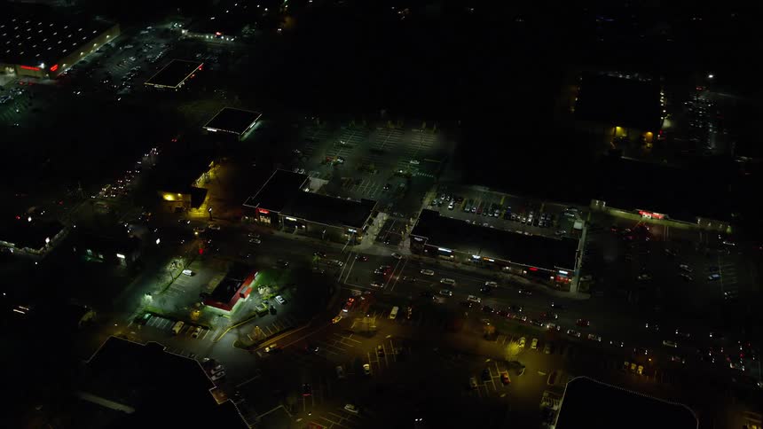 Aerial panorama of a nighttime city with streets bustling with car traffic