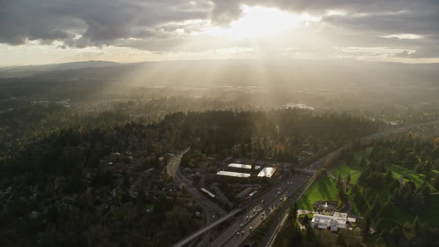 Cars travel on a busy freeway that separates neighborhoods from a golf course