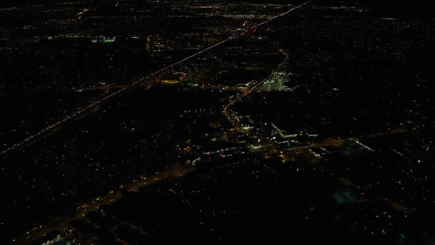 Traffic flows along roads through city at night