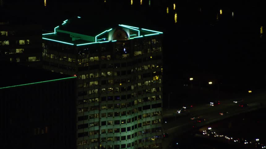 Aerial view of a skyscrapers roof lit with neon lights