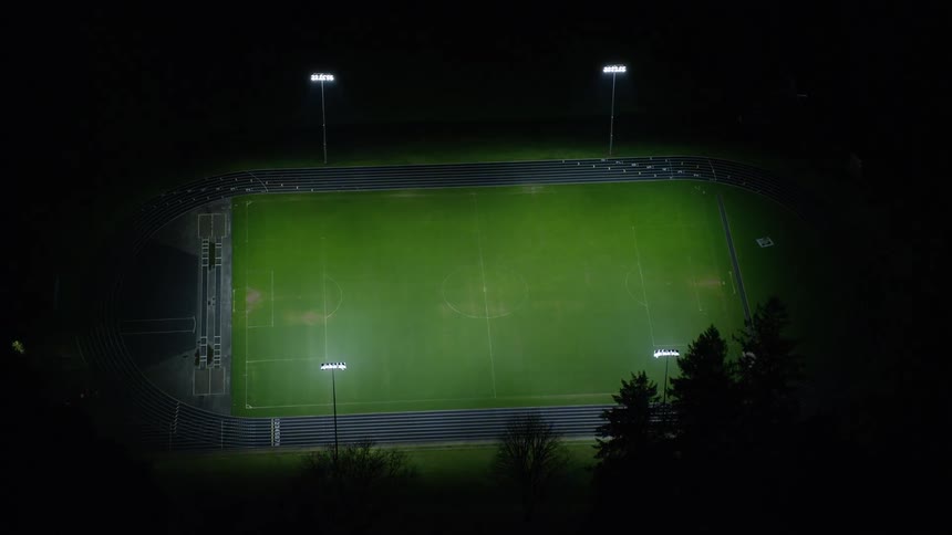 Aerial of a football field in a neighborhood at night