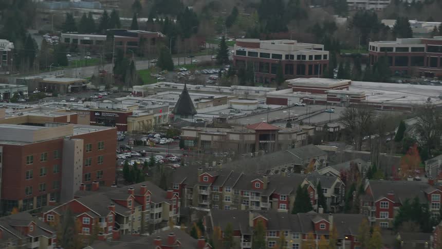 Traffic drives along street past apartment buildings and parking garages