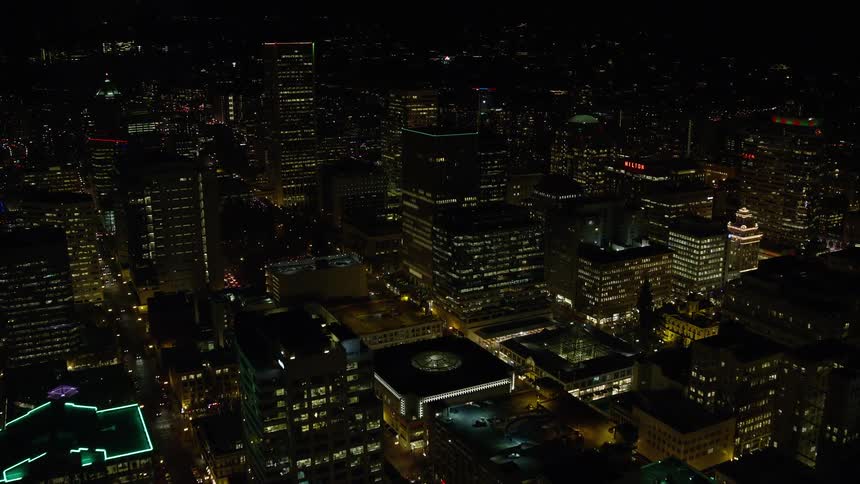 Aerial view of illuminated buildings and skyscrapers in the city at night