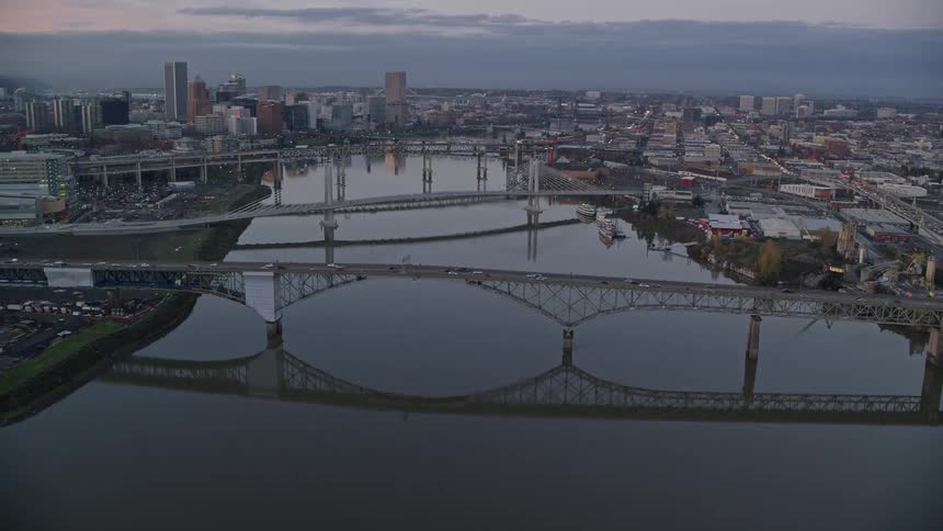 Aerial view of bridges over a river on a waterfront city at evening