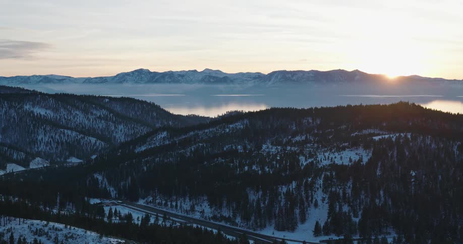The sun is rising on the lake