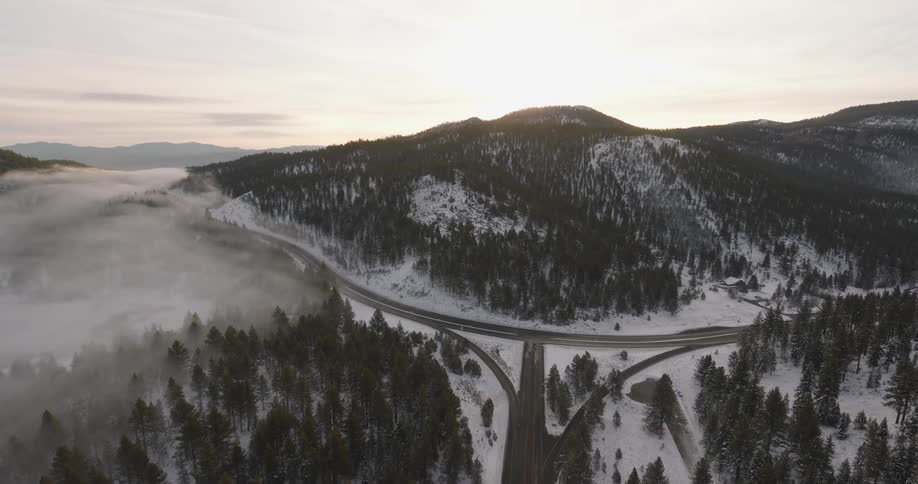 Aerial view of snow covered forest and winding roads