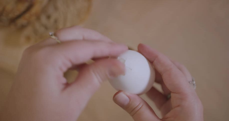 A person is peeling a hard boiled egg