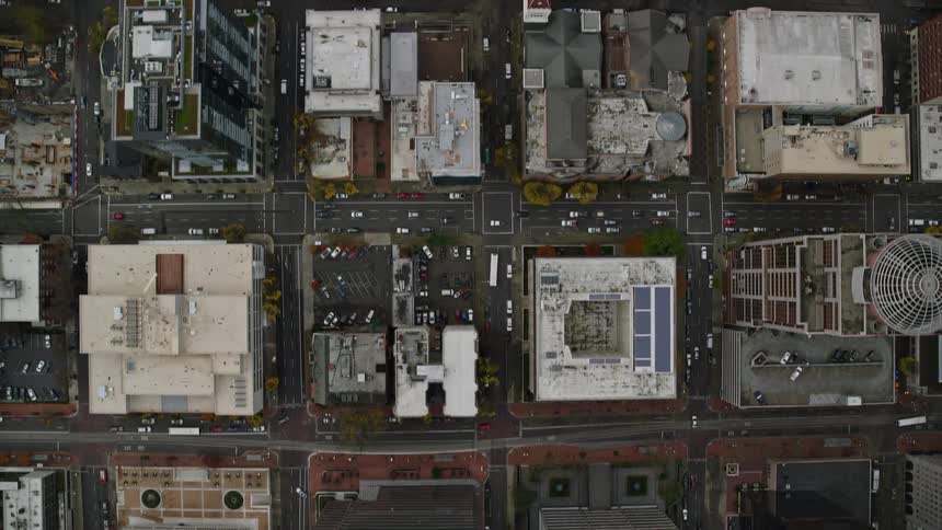 Aerial of buildings skyscrapers and moving vehicles in a metropolitan area at midday