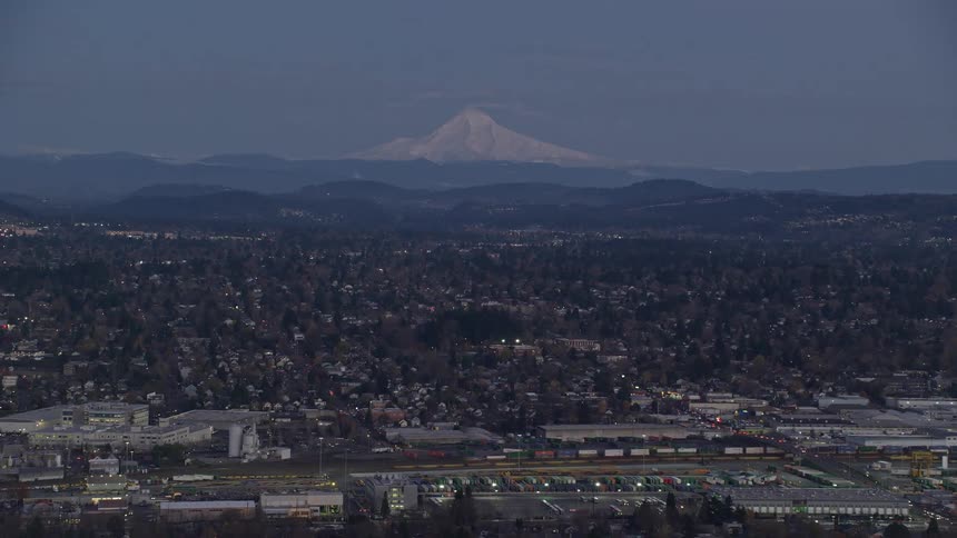 Aerial view of a city on a morning with snowcapped mountains on the horizon