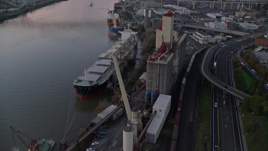 An aerial view of a cargo ship parked on a dock above the water
