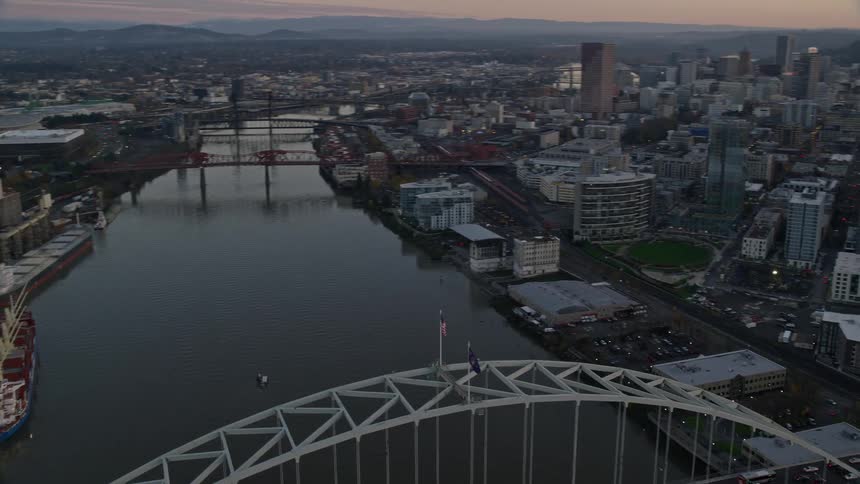 Aerial view of bridges over a river on a waterfront city at evening