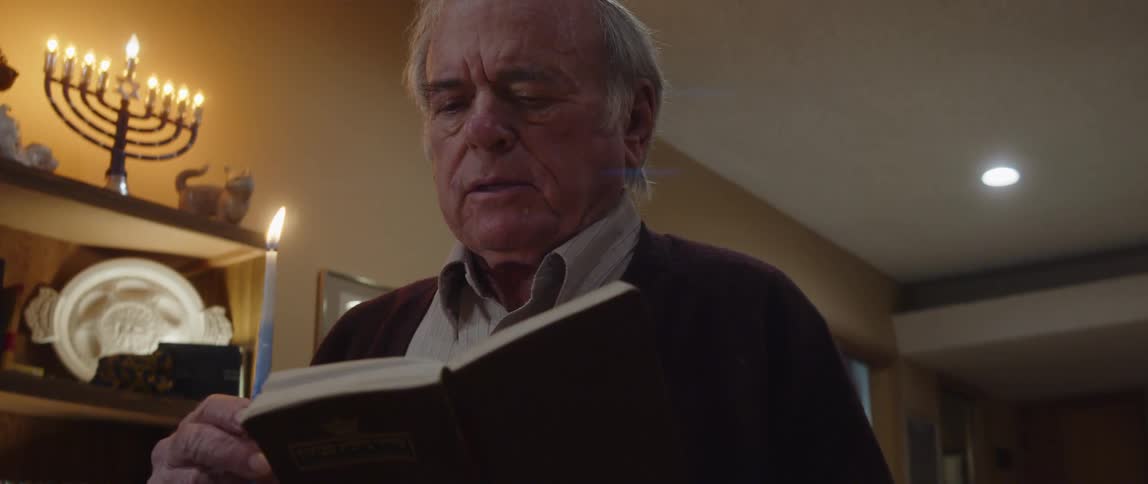 A man is praying with a candle in his hand
