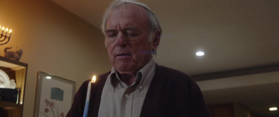 Man lights a candle before consulting a book