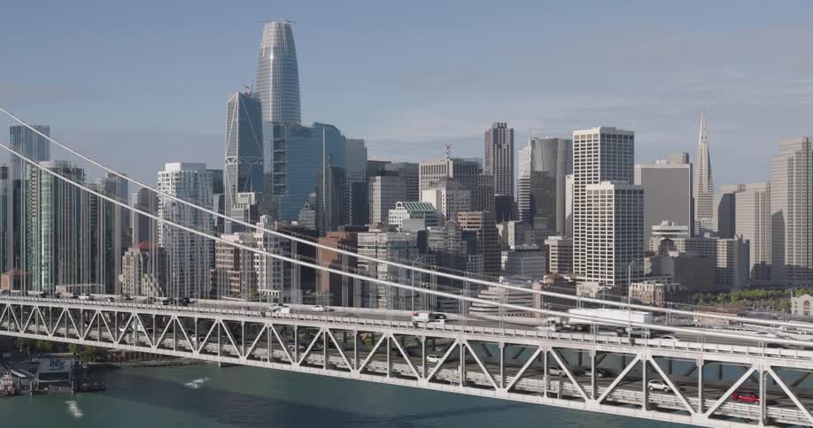 A suspended bridge with two levels with the road going in opposite directions in each leading to a large metropolitan city