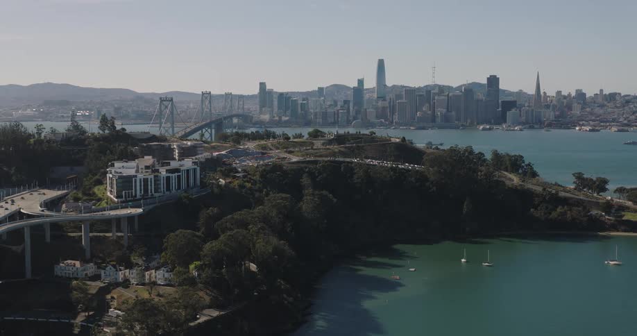 An aerial view of a large city and in front of a bridge that passes over a sea
