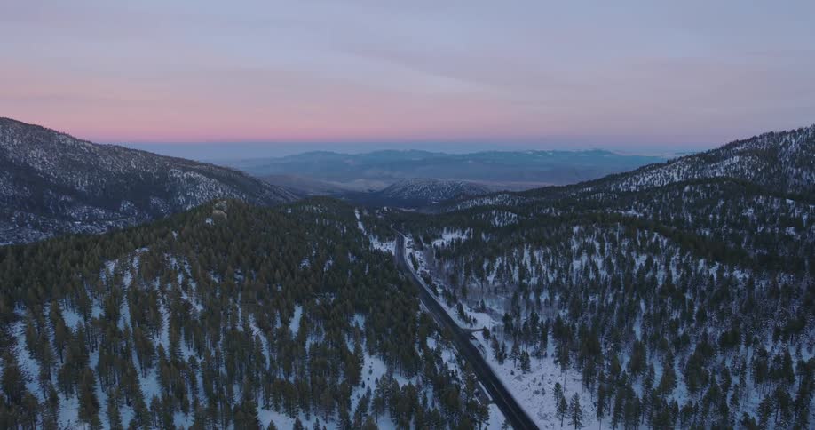 Aerial view of a road winding through the snowy mountain valley