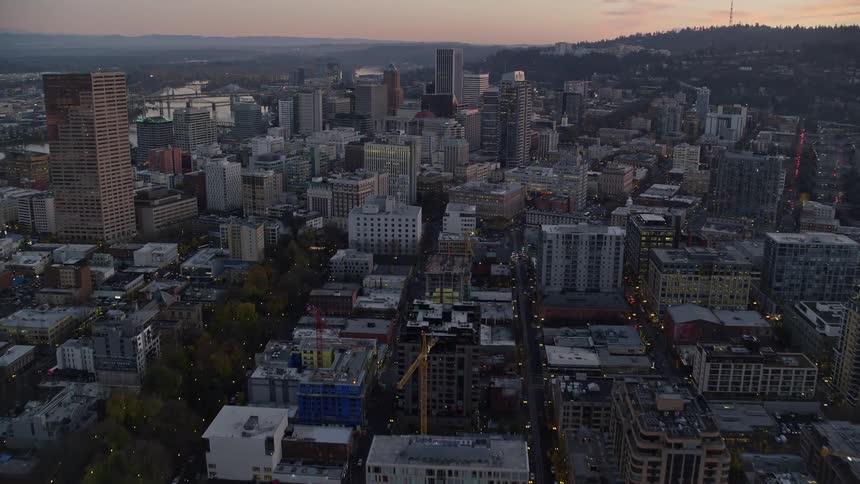 Aerial of buildings and skyscrapers in a metropolitan area at sunset