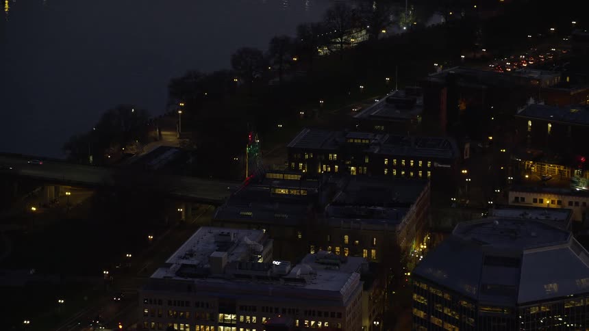 Aerial of bridge traffic and buildings in an urban area at night