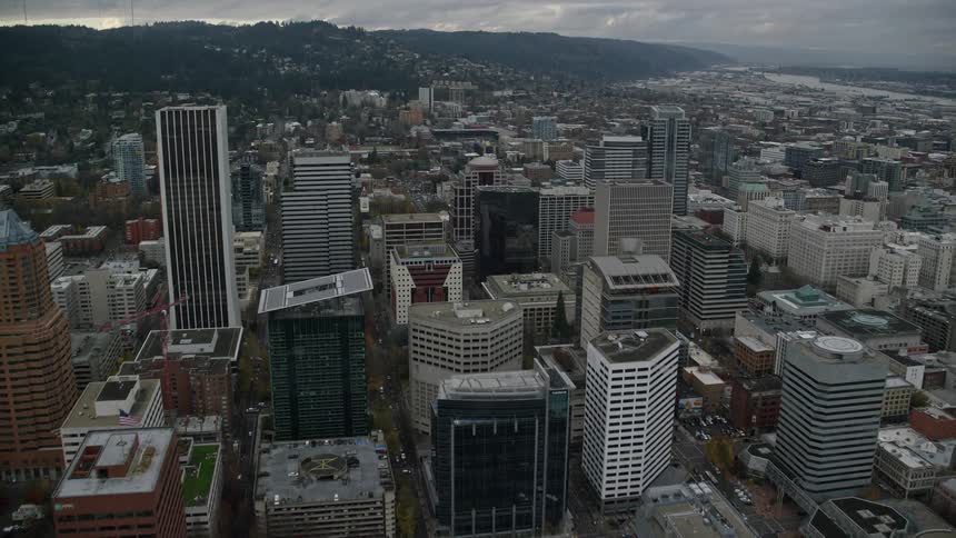 Aerial of moving cars bridges and buildings at waterfront in a metropolitan area during the day