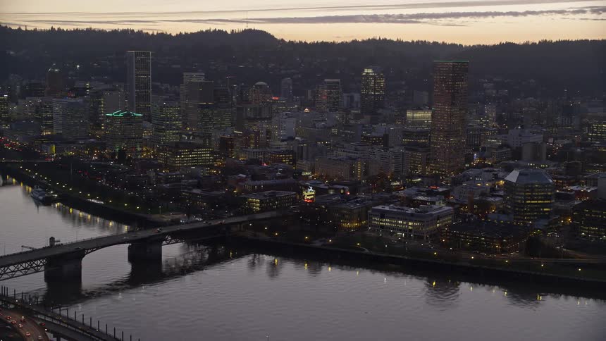 Aerial view of bridges over a river on a waterfront city at evening