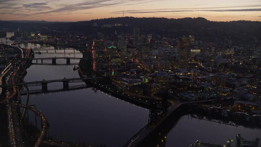 Aerial view of bridges over a river on a waterfront city at evening