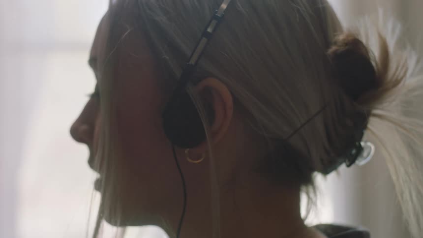 Closeup of a womans face putting on a headset