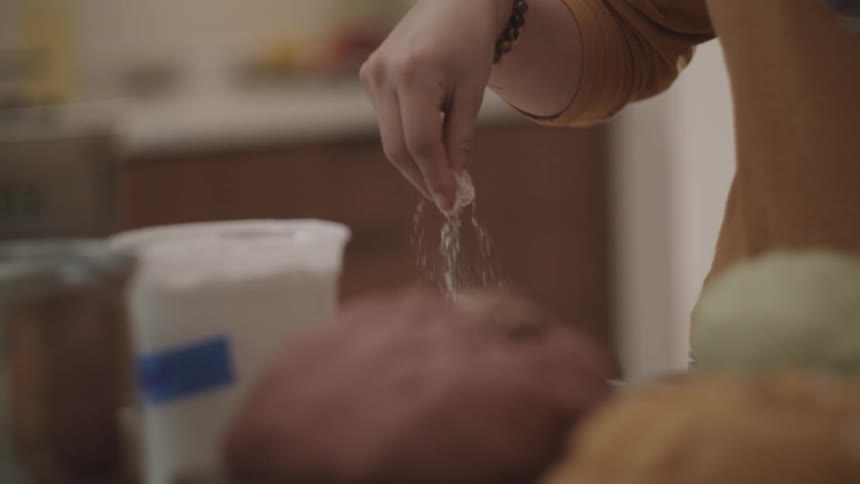 A person seasoning ingredients for a meal