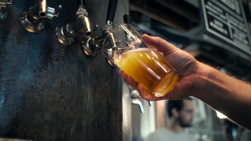 A glass is being filled with beer at the tap