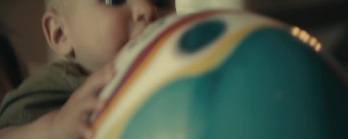 Mother interacting with her young son who is holding a toy in his hands