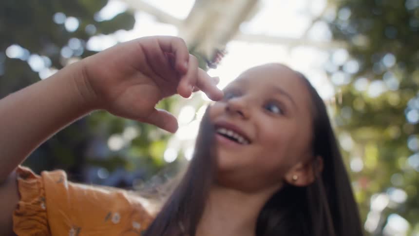 Closeup of a girls face with a butterfly in her hands