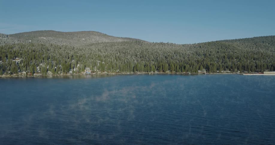 Aerial view of light mist over a lake near the mountains