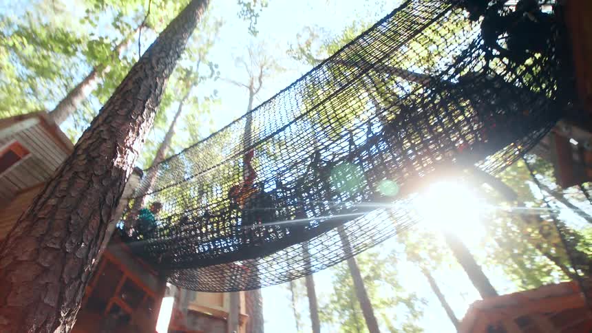 Upward view of a rope bridge with children crossing