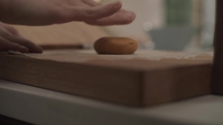 Flattening a piece of dough in the kitchen