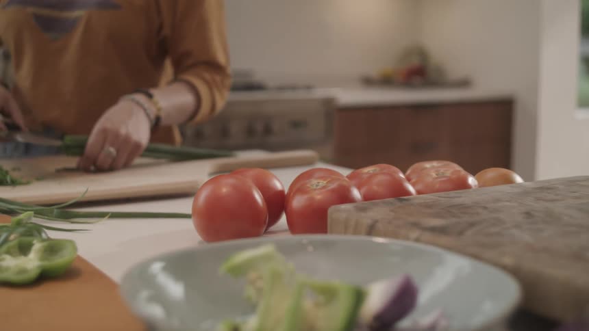 Family cutting and slicing vegetables in the kitchen at home