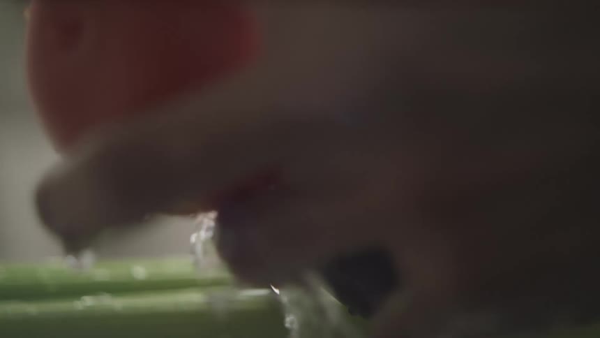 Person washing multiple vegetables with water using their hands