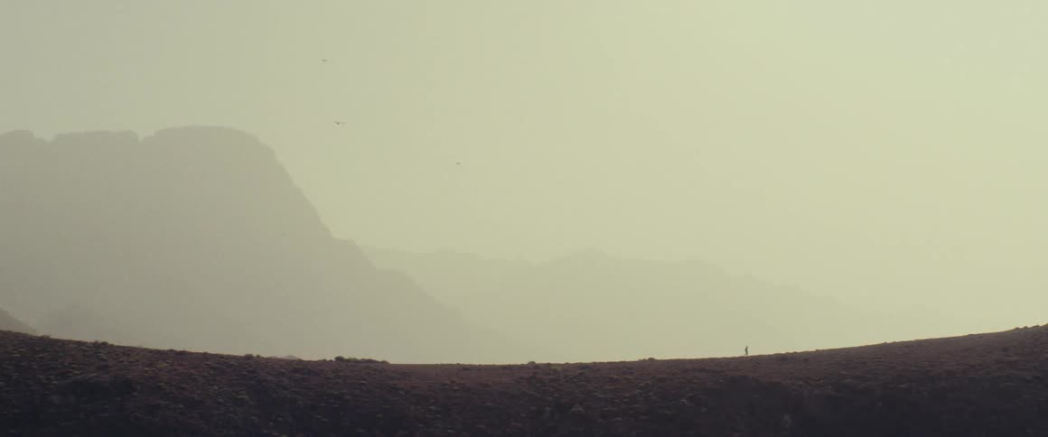Someone hiking in the distance about to go up a hill