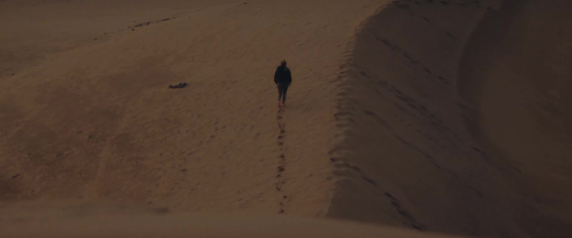 Man walking away in the middle of the desert