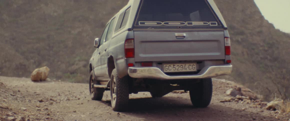 A truck is parked by the mountain