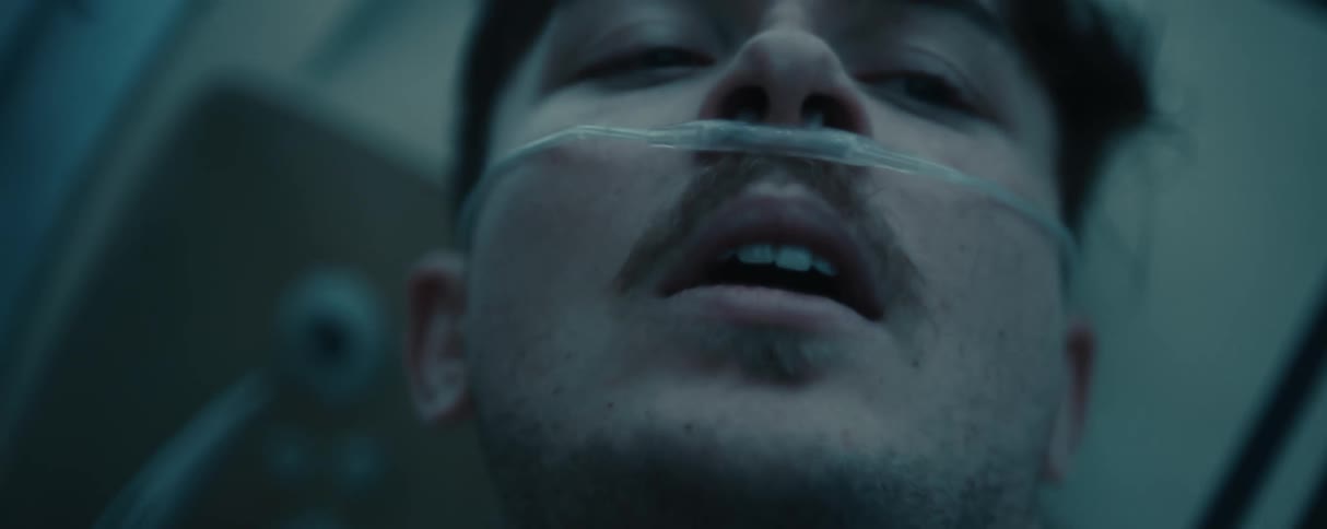 Close up of the face of a man wearing a nasal cannula