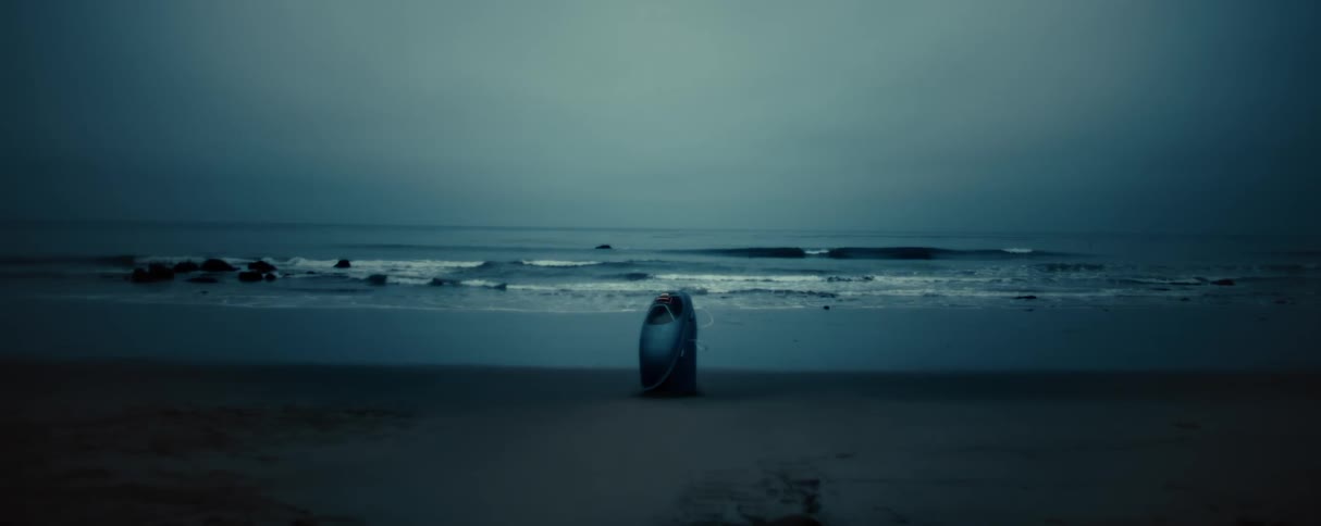 Small machine stands on the shoreline of a beach
