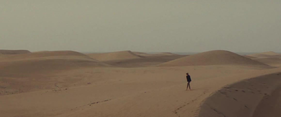 Person walking through the desert and sand dunes
