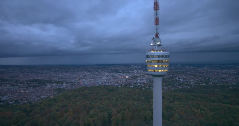 Panorama of a tower on an observation deck with an urban city in the background under a cloudy sky