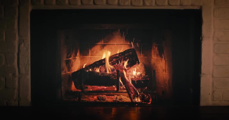 Burning fire inside an indoor fireplace at night