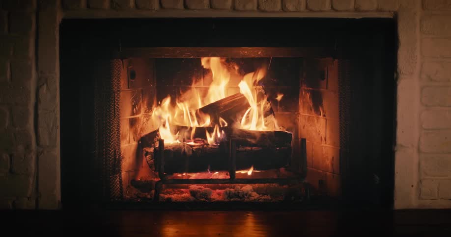 Logs burn in a fireplace as flames flicker and waver